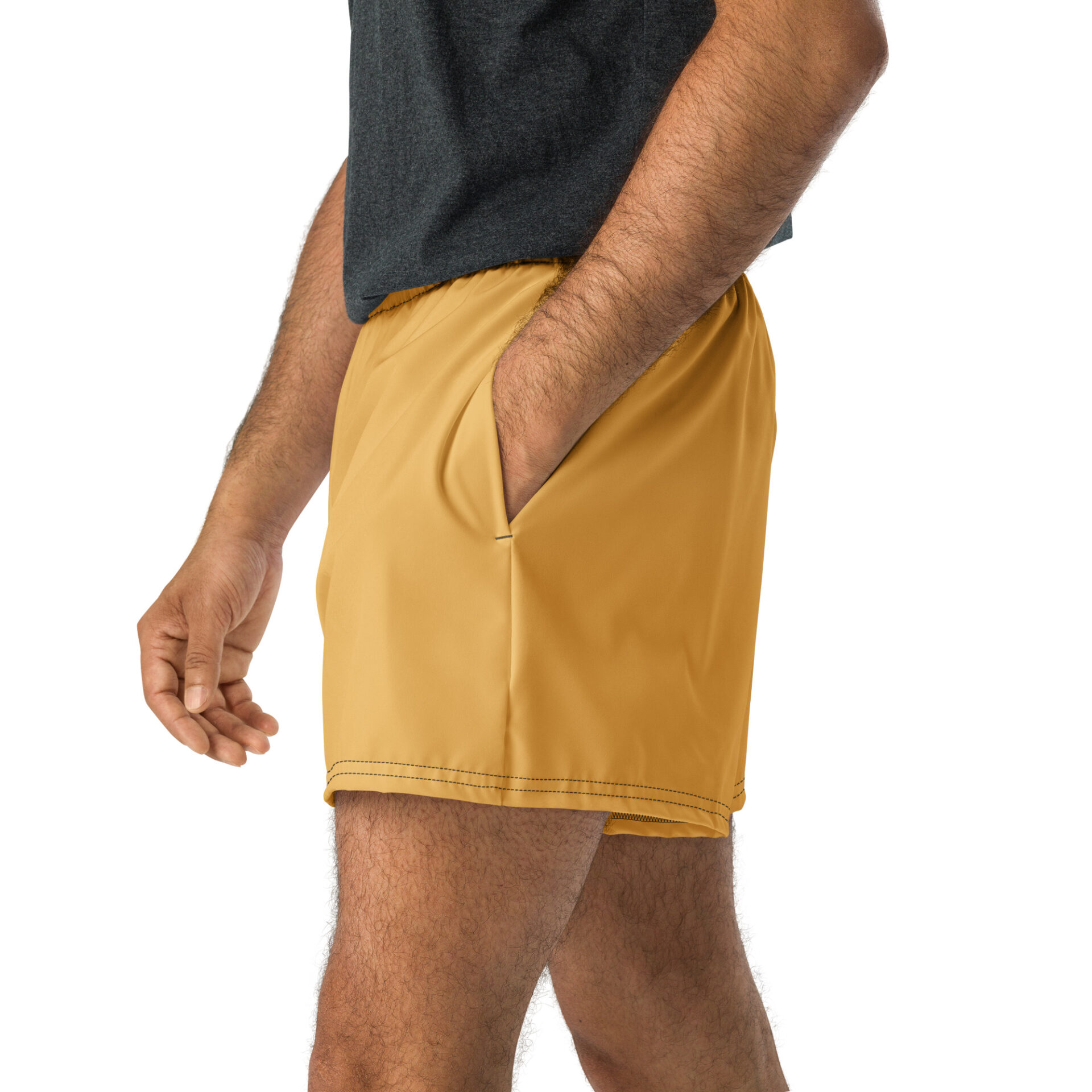Someone wearing a dark gray shirt and CHAMP Golden Athletic Shorts stands with one hand in the shorts pocket against a white background.