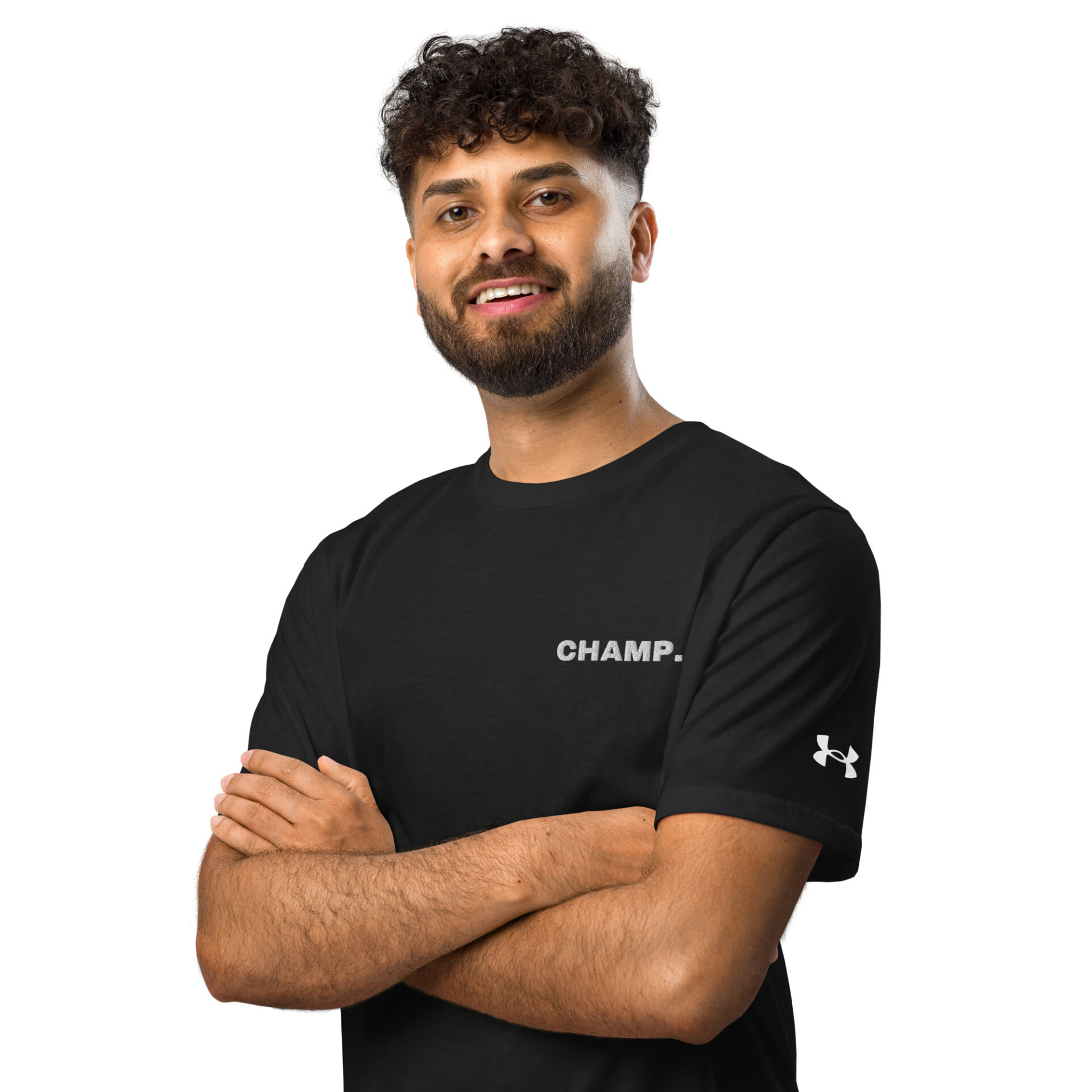 A bearded man with curly hair smiles with arms crossed, wearing an Under ArmourⓇ athletic t-shirt CHAMP against a plain white background.