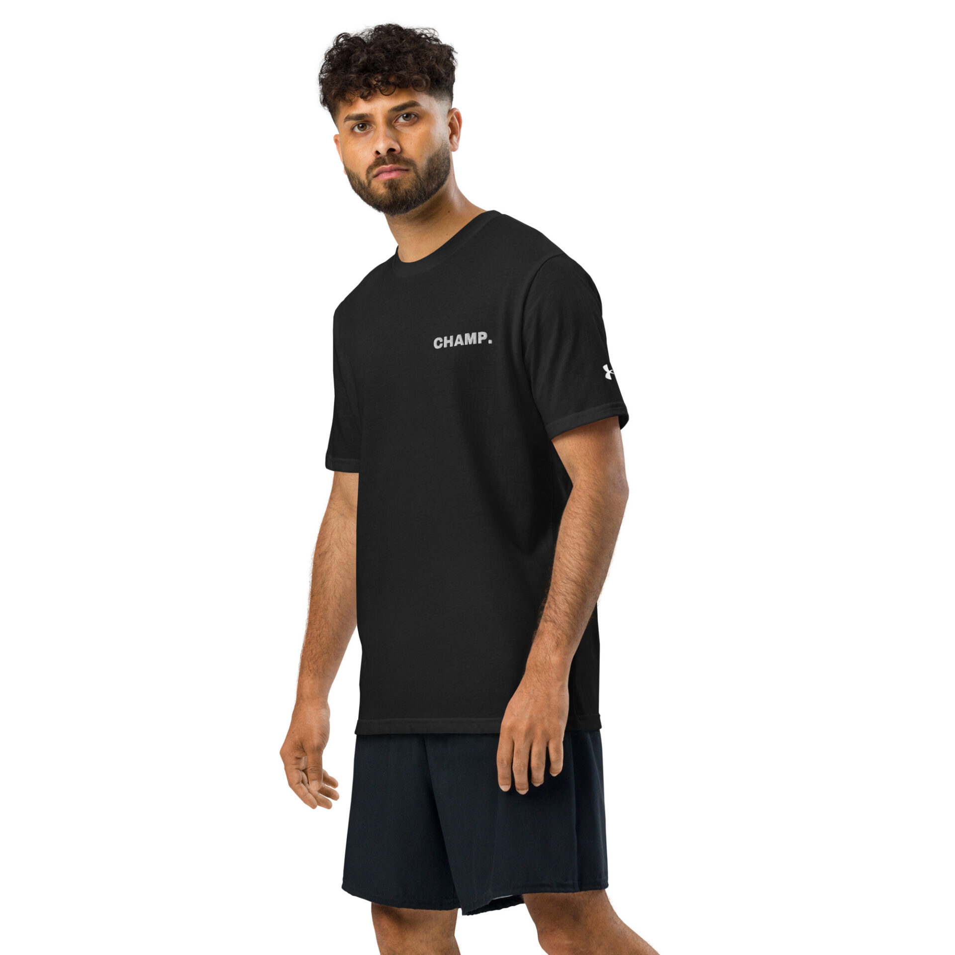 A man with curly hair and a beard wears a black Under ArmourⓇ athletic t-shirt CHAMP and black shorts, standing against a plain white background.