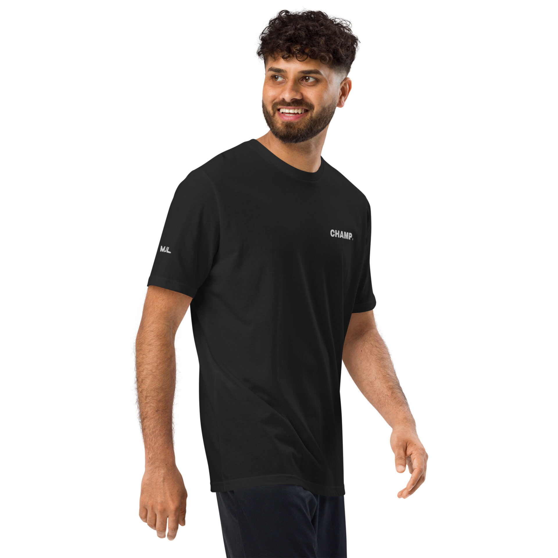 A man with curly hair and a beard is smiling as he walks, wearing the Under ArmourⓇ athletic t-shirt CHAMP featuring CHAMP. on the chest. The background is plain white.