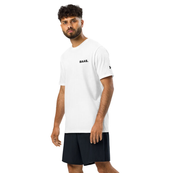 A man with curly hair and a beard wears a white Under ArmourⓇ athletic t-shirt with BAAS. printed on it and black shorts, standing against a plain white background.