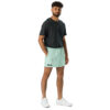 A man with short curly hair and a beard stands against a white background wearing MJL Athletic Shorts, a dark gray t-shirt, and white sneakers, highlighting comfortable sportswear ideal for casual outings.