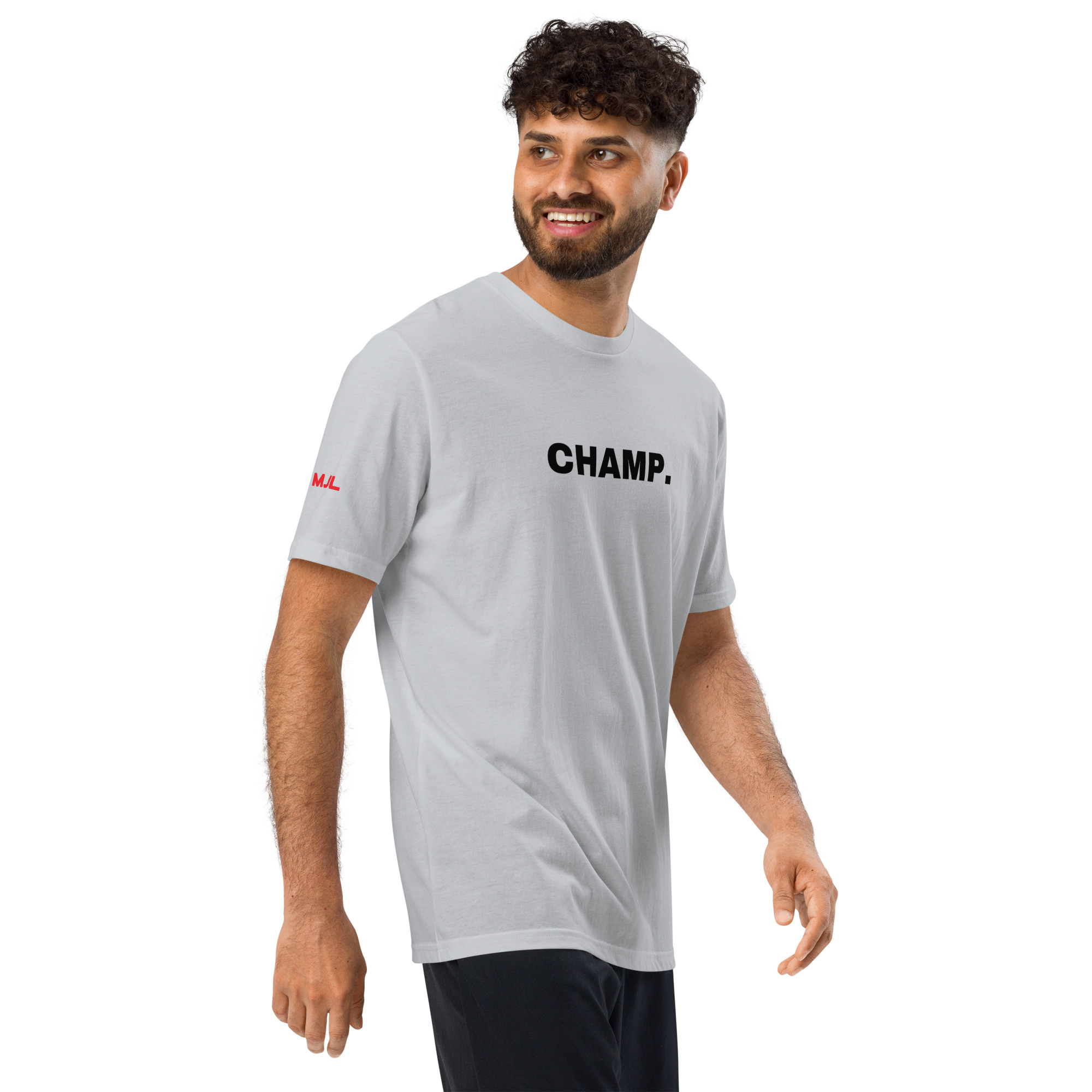 A man with curly hair and a beard is smiling and walking while wearing black pants and a light gray Under ArmourⓇ athletic t-shirt embroidered with "CHAMP" in bold black letters. A man with curly hair and a beard is smiling and walking while wearing black pants and a light gray Under ArmourⓇ athletic t-shirt embroidered with "CHAMP" in bold black letters.